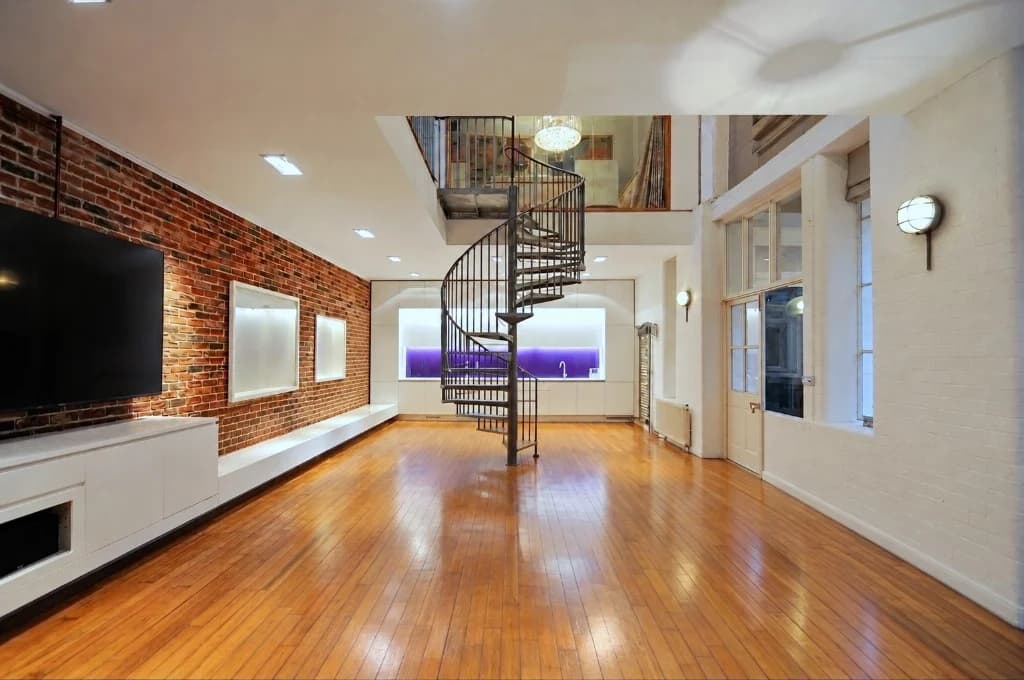 Open-plan loft with spiral staircase — before virtual staging