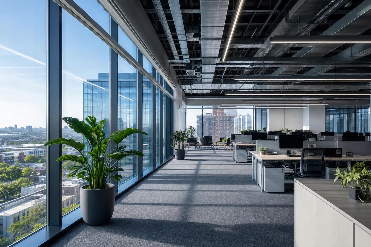 Open-plan commercial office floorplate with workstations and city skyline, photographed by Photoplan
